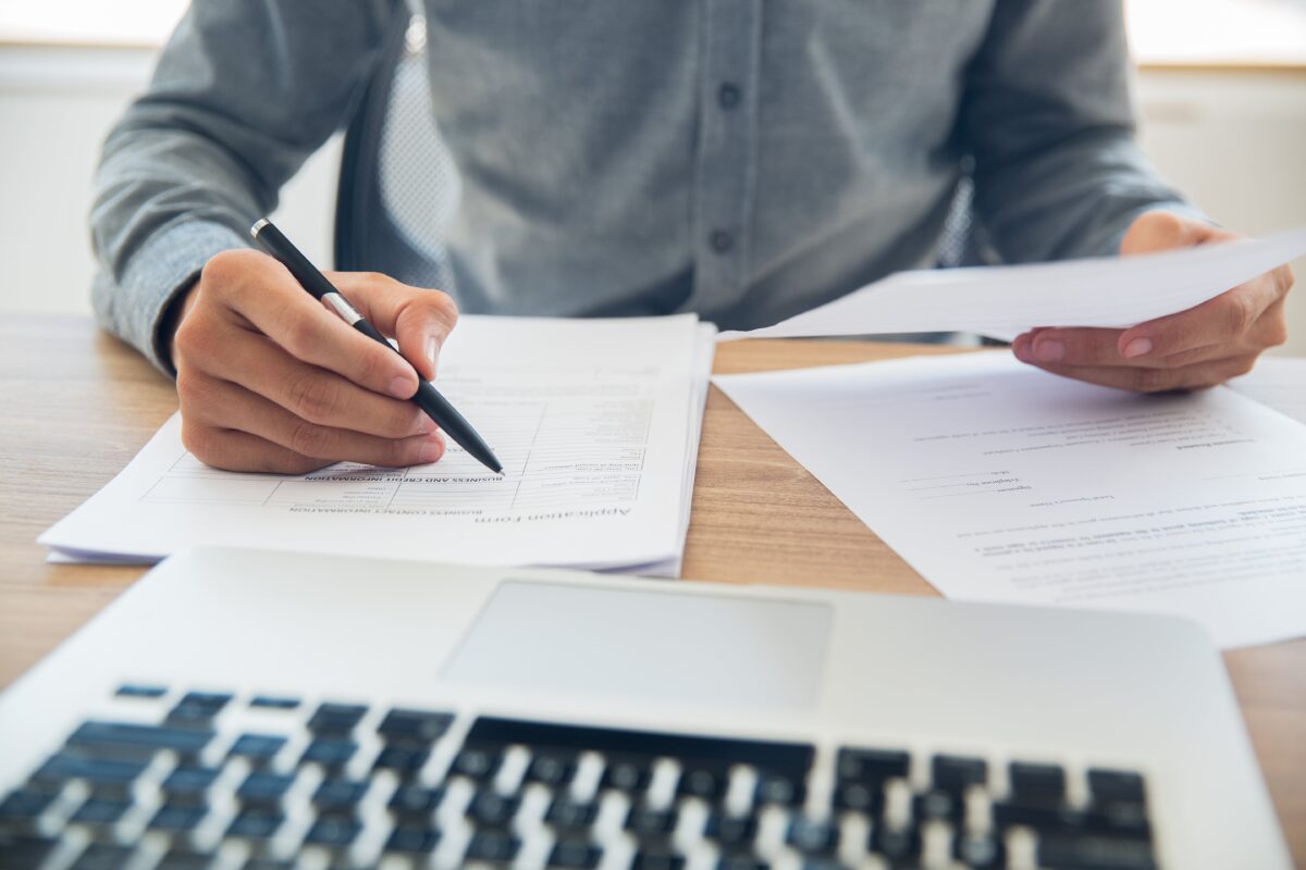 businessman-checking-documents-table-min