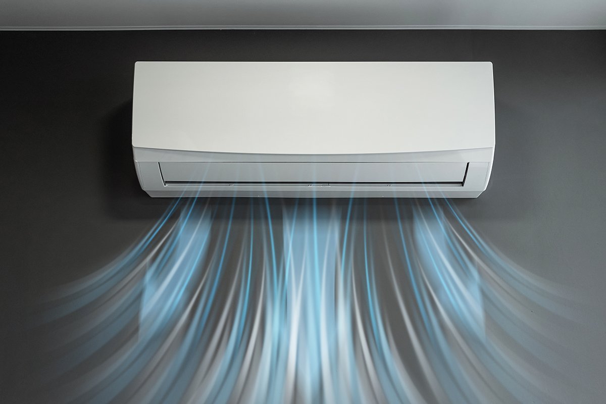 White air conditioning and a stream of fresh cold air on a background of a gray wall. The concept of heat, cool air, cooling, freshness.