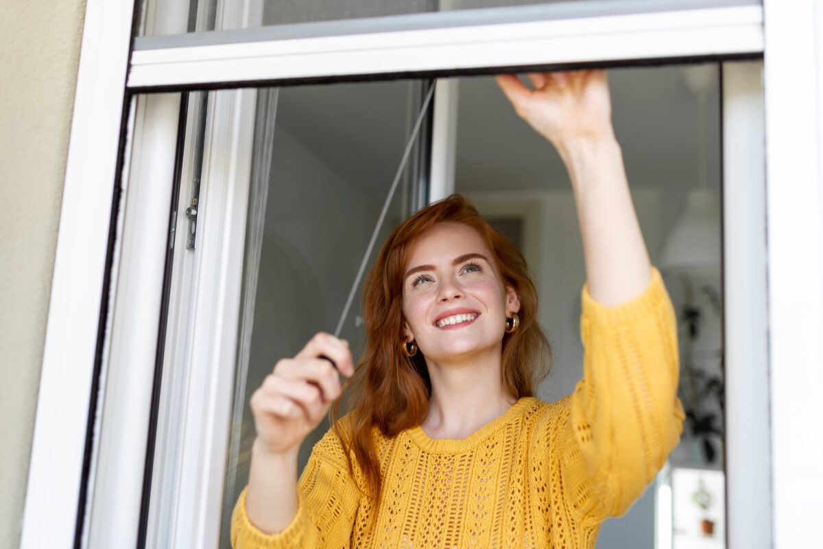 woman-hand-hold-retractable-pleated-insect-screen-holder-to-open-or-close-the-window-mosquito-nets-min